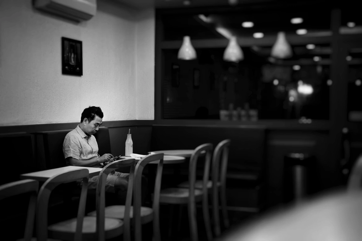 Man sitting in a cafe holding a smartphone